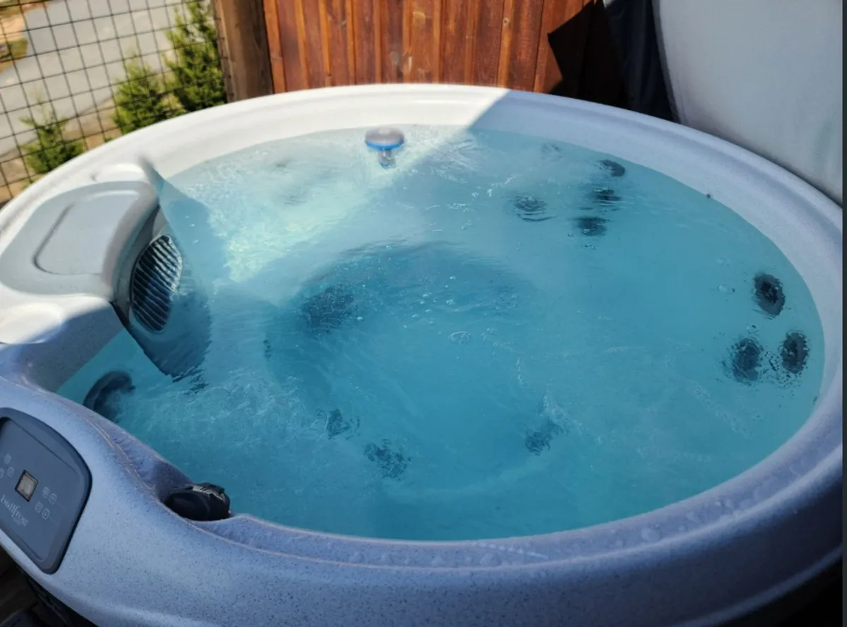 A tranquil hot tub scene with water rippling beneath the sunset, inviting guests to unwind while taking in the beauty of the natural surroundings. The ambiance is serene and rejuvenating, suggesting opportunities for relaxation after an active day.